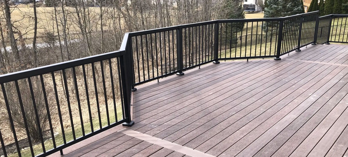 Brown composite deck with black metal railings installed by professionals